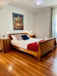 1 dormitorio con 1 cama y una pintura en la pared en Agradable casa con jacuzzi climatizado exterior en pleno Urdaibai, en Busturia