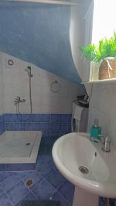 a blue and white bathroom with a sink and a shower at Olyna’s Apartment N.S Preveza in Néa Sampsoús