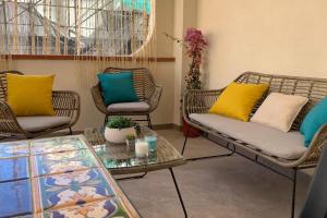 sala de estar con sillas de mimbre y mesa en Casa Franca a Marzamemi en Marzamemi