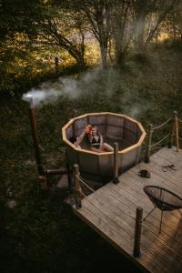 a woman in a bath tub on a wooden deck at Na miły Bug Guesthouse by Bug river 