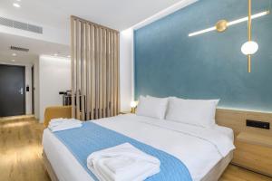 Acropolis Magenta Luxury Suites في أثينا: غرفة نوم بسرير كبير بجدار ازرق