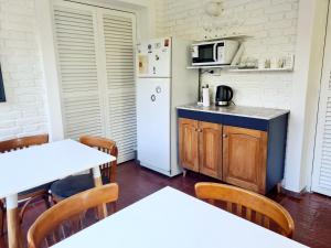 eine Küche mit einem weißen Kühlschrank sowie Tischen und Stühlen in der Unterkunft Casa del Buen Viaje in Mendoza