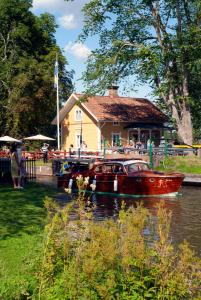 Hajstorp Slusscafé & Vandrarhem في توريبودا: قارب في الماء بجوار منزل