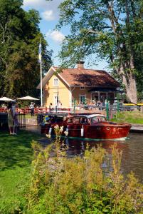 a boat in the water next to a house at Hajstorp Slusscafé & Vandrarhem in Töreboda