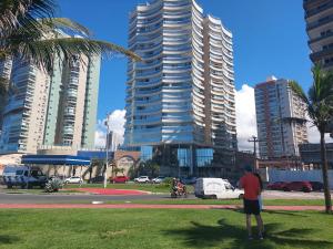 Un uomo in piedi in un parco di fronte a edifici alti di Meu sonho realizado! Muito charmoso e acolhedor. a Vila Velha