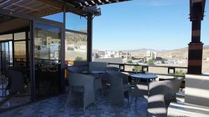 eine Terrasse mit Stühlen und Tischen auf dem Balkon in der Unterkunft Hotel Riad Taounate in Taounate