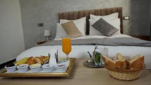 Hotel Riad Taounate في تاونات: صينية طعام على طاولة بجوار السرير