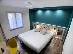 um quarto com uma grande cama branca e uma parede verde em Eco-Appart'hôtel Rouen / SLT em Rouen