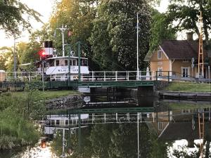 um barco está ancorado ao lado de uma ponte em Hajstorp Slusscafé & Vandrarhem em Töreboda