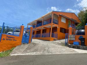 an orange building with a sign in front of it at Le Papillon Bleu in Bouillante