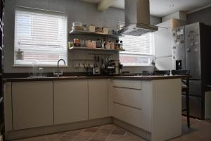 Protea Homestay في مانشستر: مطبخ مع مغسلة وثلاجة