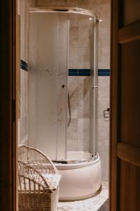 a glass shower in a bathroom with a tub at Na miły Bug Guesthouse by Bug river 
