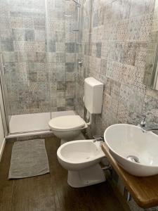 uma casa de banho com um WC, um lavatório e um chuveiro em Nuovo bilocale a 150 mt dal mare em Porto Torres