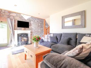 a living room with a couch and a fireplace at Gwennol Cottage in Carmarthen