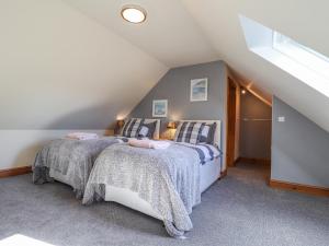 a bedroom with two beds in a attic at Gwennol Cottage in Carmarthen