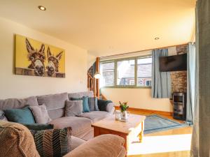 a living room with a couch and a table at Barcud Cottage in Carmarthen