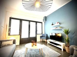 a living room with a couch and a table and a tv at Maison Gabriel - charmant lieu de vie pour 8 pers. in Berck-sur-Mer