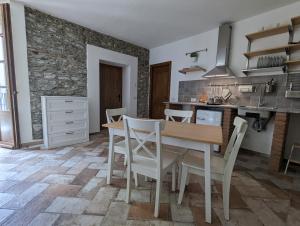 a kitchen and dining room with a table and chairs at Antica Osteria Apartments in Dongo