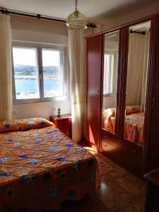 1 dormitorio con 2 camas y 2 ventanas en EnSAN CIPRIÁN Faro de Punta Atalaya, en Cervo