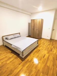 una camera con letto e pavimento in legno di Lux apartman Ub a Ub