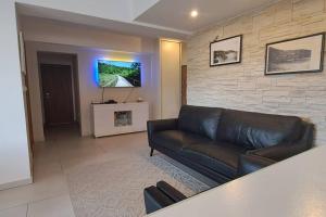 een woonkamer met een leren bank en een tv bij NEW apartmant for 5 in Solin