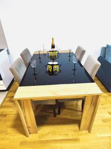 uma mesa de jantar com copos de vinho e uma mesa preta em Stan na dan max 4 em Ub