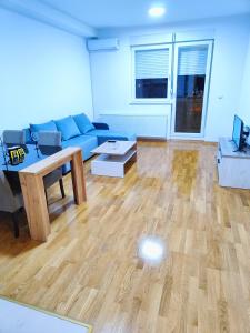 a living room with a blue couch and a table at Apartment luxury Ub in Ub