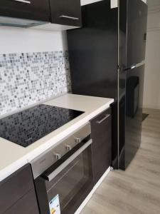cocina con nevera de acero inoxidable y encimera blanca arriba en Bucium Apartament en Iaşi