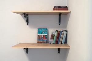 a wooden shelf with books on a wall at Feneri 3 -Cozy rustic Apt 20' from Elafonisi beach in Perivólia