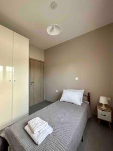 um quarto com uma cama com duas toalhas brancas em Zouf house em Panayía Mesosporítissa