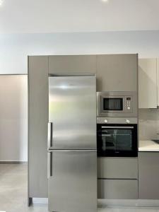 uma cozinha com um frigorífico de aço inoxidável e um micro-ondas em Zouf house em Panayía Mesosporítissa