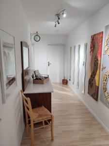 un couloir avec une chaise et des peintures murales dans l'établissement Ferienwohnung Schloßgast im Oberen Donautal, à Hausen im Tal