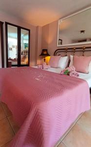 a large pink bed in a room with a mirror at Olyna’s Apartment N.S Preveza in Néa Sampsoús