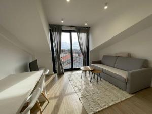 a living room with a couch and a large window at Mini Condos® 30DL - Studio 2 minutes to waterfront in Tivat