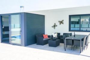 patio z czarnym stołem i krzesłami oraz stołem i szezlongiem w obiekcie Villa Dolores w mieście Dolores