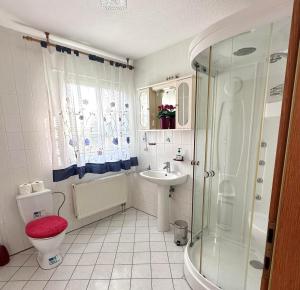 ein Bad mit einer Dusche, einem WC und einem Waschbecken in der Unterkunft Homestay Sweet Island in Gager