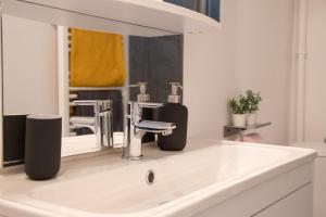biała umywalka w łazience z lustrem w obiekcie *Le Cosy* 3 chambres hypercentre - Parking - Wifi w Awinionie