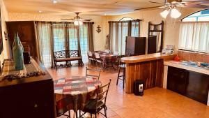 a kitchen and living room with a table and chairs at Casa Encantada offers you Two-Bedroom House, 1 Tiny Apartment & 3 Double Rooms in Manuel Antonio