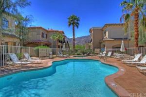 una piscina con sillas y palmeras en La Quinta Gem 1 BR Pool Hot Tub Sleeps 4, en La Quinta