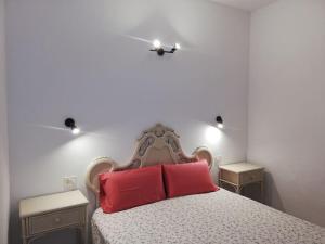 ein Schlafzimmer mit einem Bett mit zwei roten Kissen in der Unterkunft apartamento CASA TELA in Tazacorte