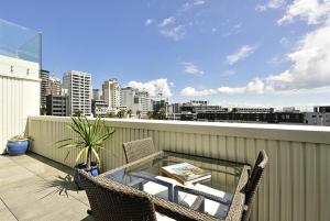 een patio met stoelen en een tafel op een balkon bij The Landings Parnell in Auckland