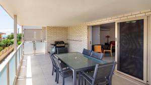 a patio with a table and chairs on a balcony at Gone Coastal - Three Bedroom Unit in Woorim