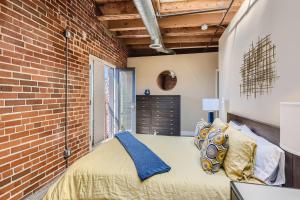丹佛的住宿－1515 Ogden Apt 7，一间卧室设有砖墙和一张床