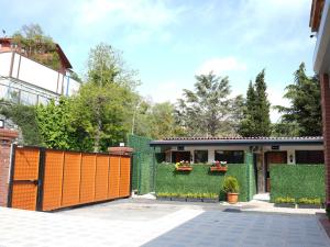 a house with an orange gate and green hedge at Mia Mia Suites in Istanbul