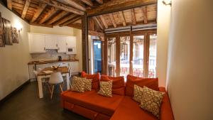 a living room with an orange couch and a kitchen at Tiempo de Toledo in Toledo