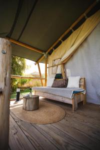 Tienda de Safari Almagro في مونتيهمورتو: غرفة نوم بسرير في خيمة