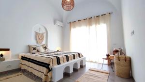 a bedroom with a bed and a large window at Villa Pupputia Hammamet M'rezga beach in Nabeul