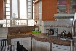 a kitchen with white cabinets and a counter top at Très bel appartement au centre d'Agadir, in Agadir