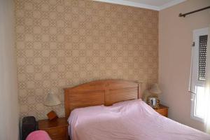 a bedroom with a bed with a pink bedspread at Très bel appartement au centre d'Agadir, in Agadir