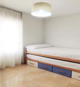 1 dormitorio con 2 camas y ventana en Accommodation Campanario de la Magdalena en Córdoba